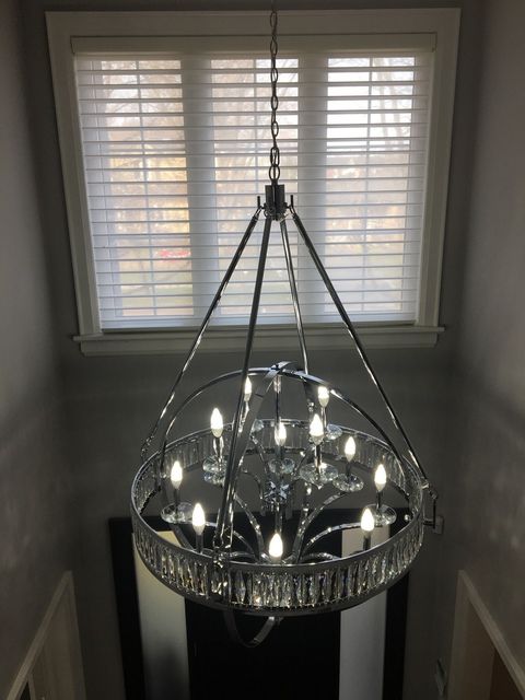 A chandelier is hanging from the ceiling in front of a window.