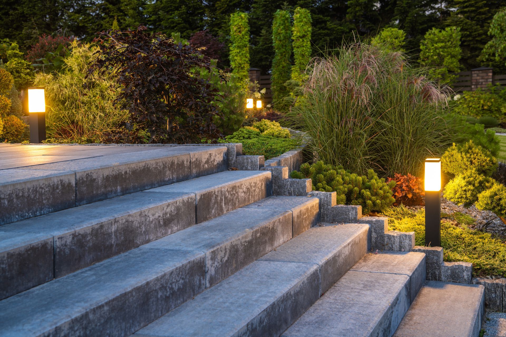 A set of stairs with lights on them in a garden.
