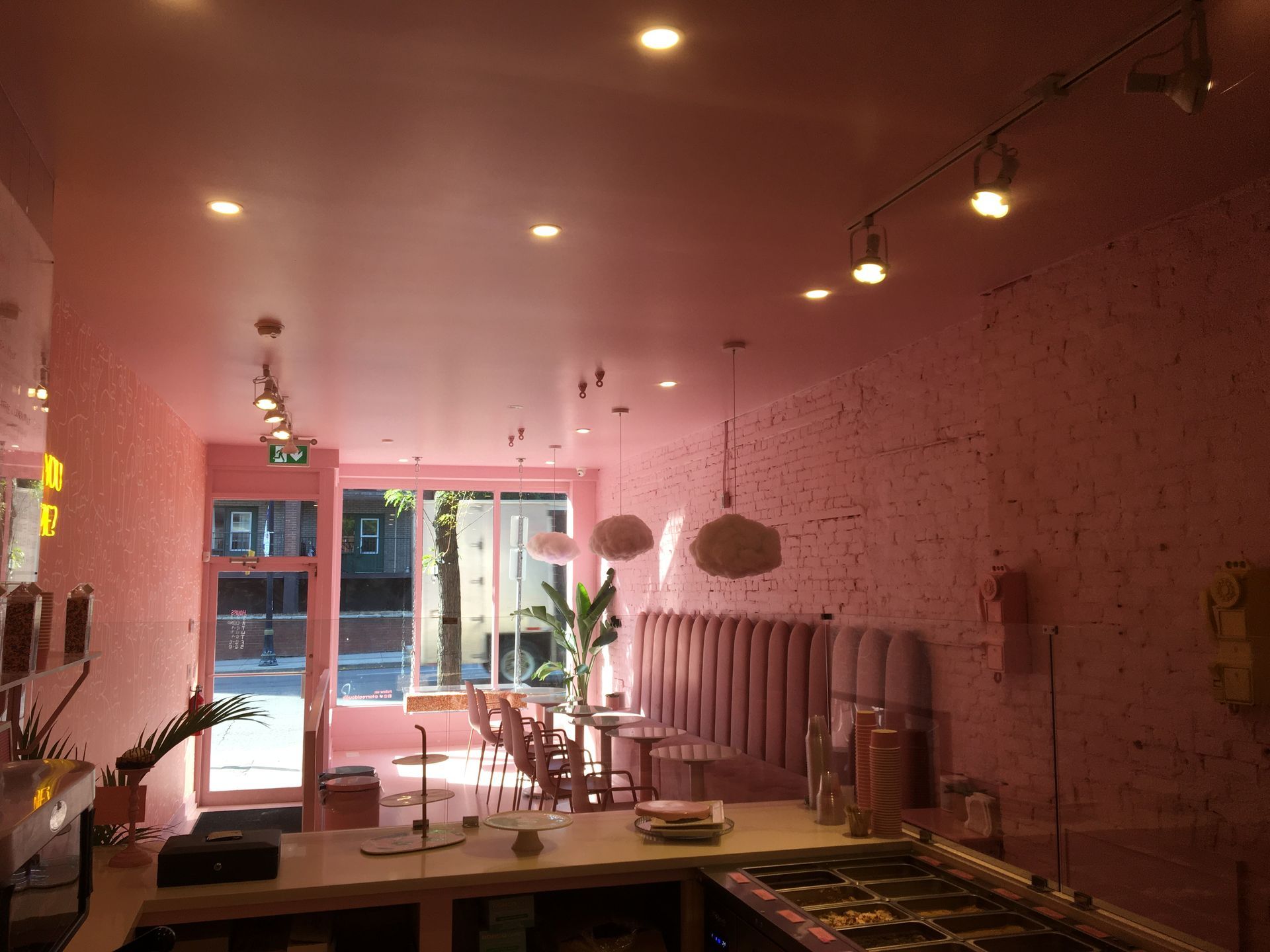 A restaurant with pink walls and tables and chairs