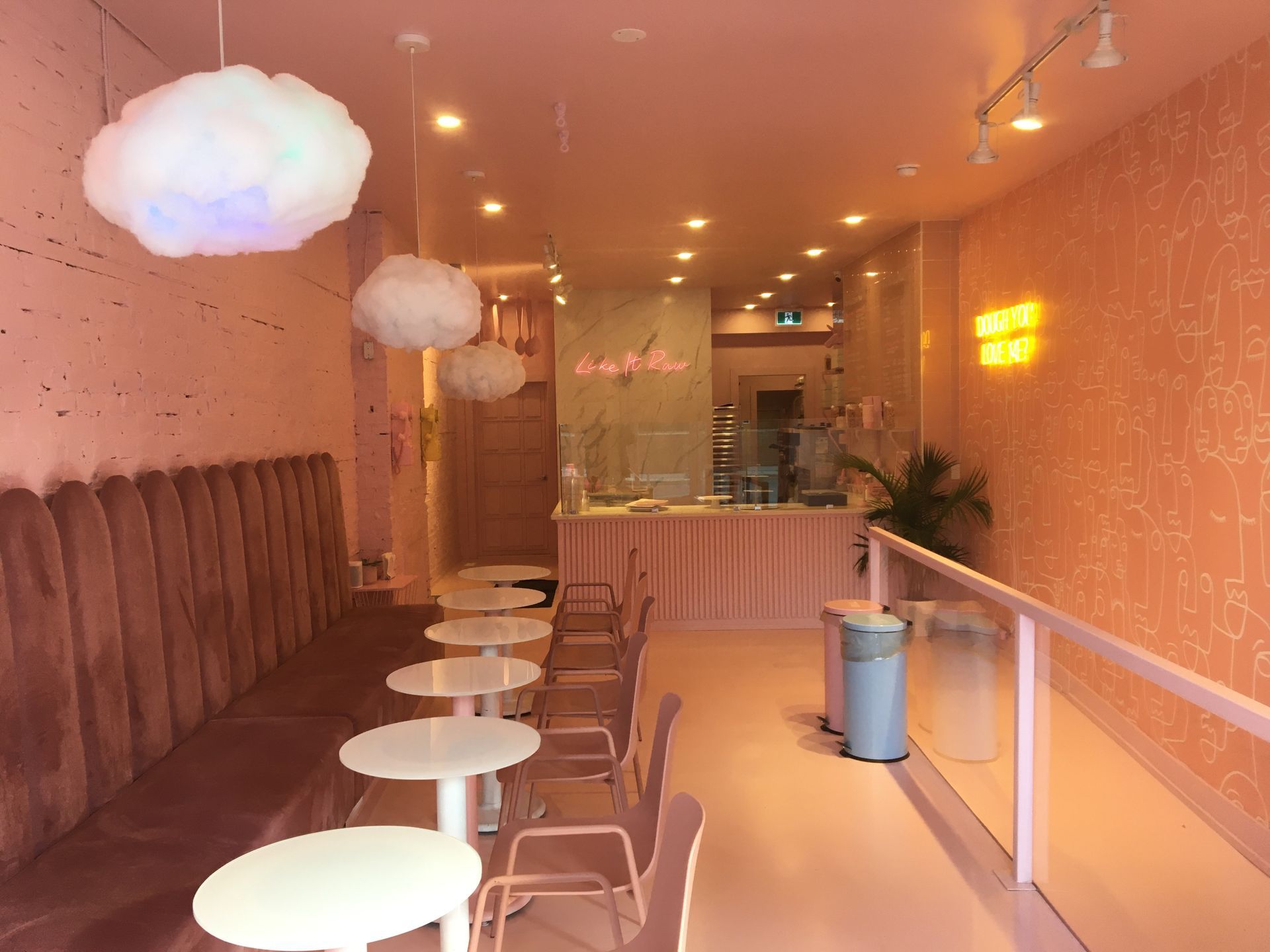 A restaurant with pink walls and tables and chairs