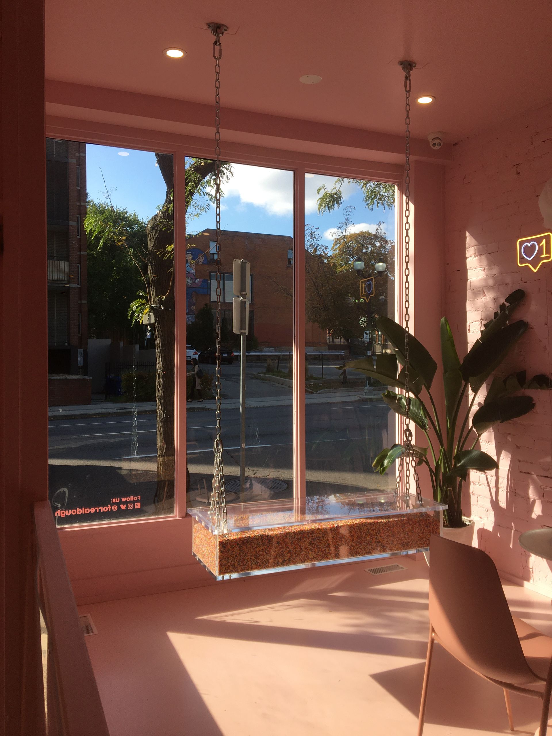 A pink room with a swing hanging from the ceiling