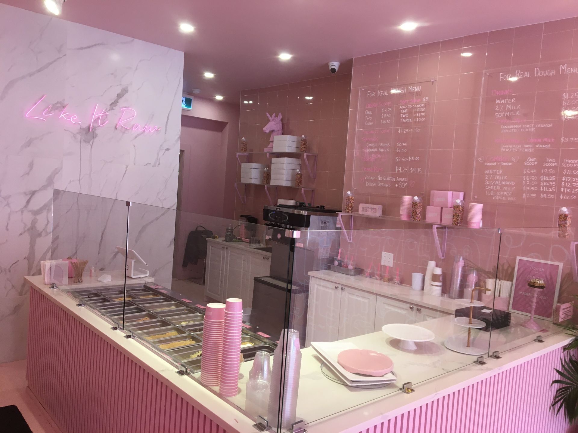 The inside of a pink and white ice cream shop.