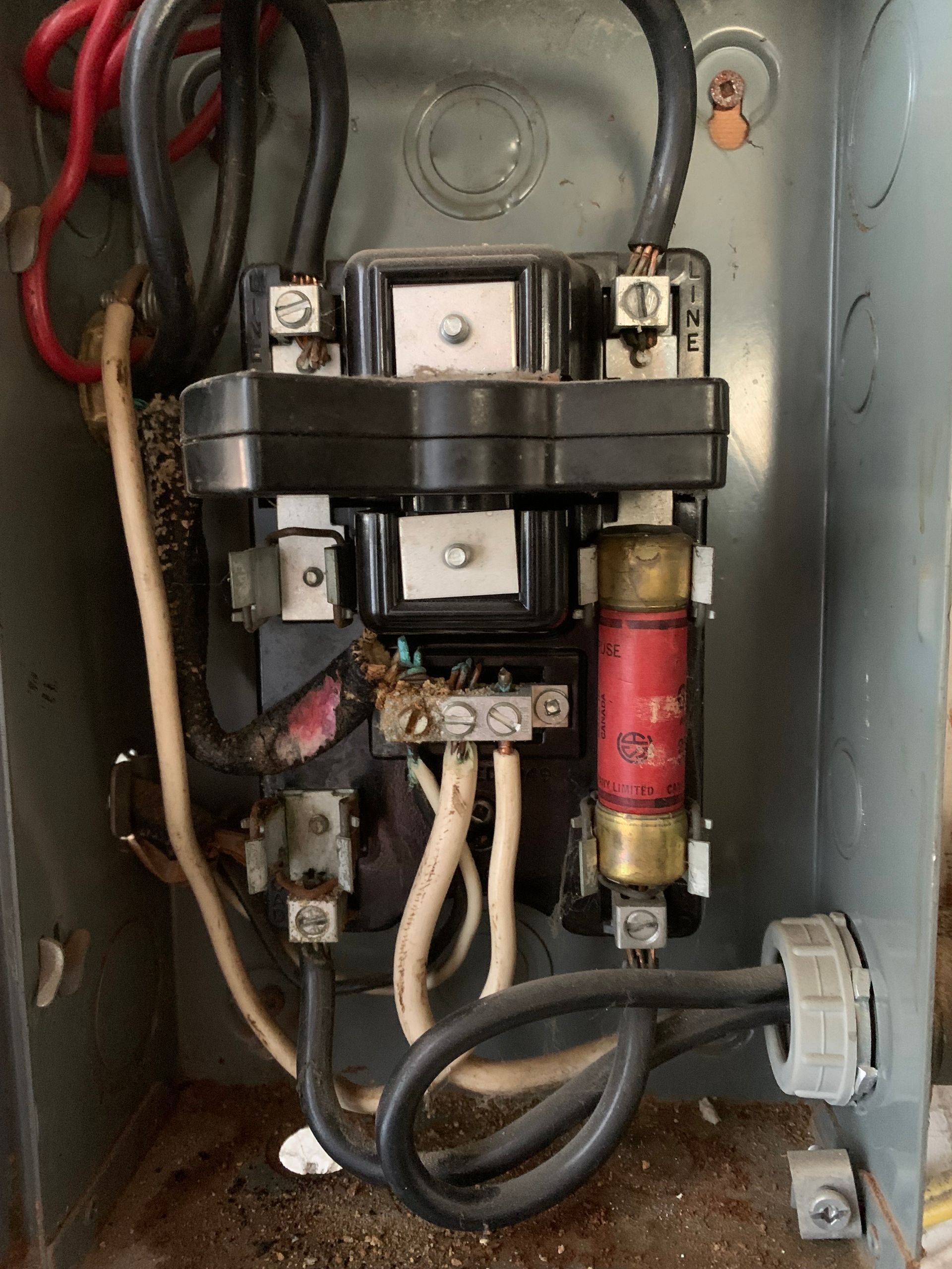 A close up of a electrical box with wires coming out of it