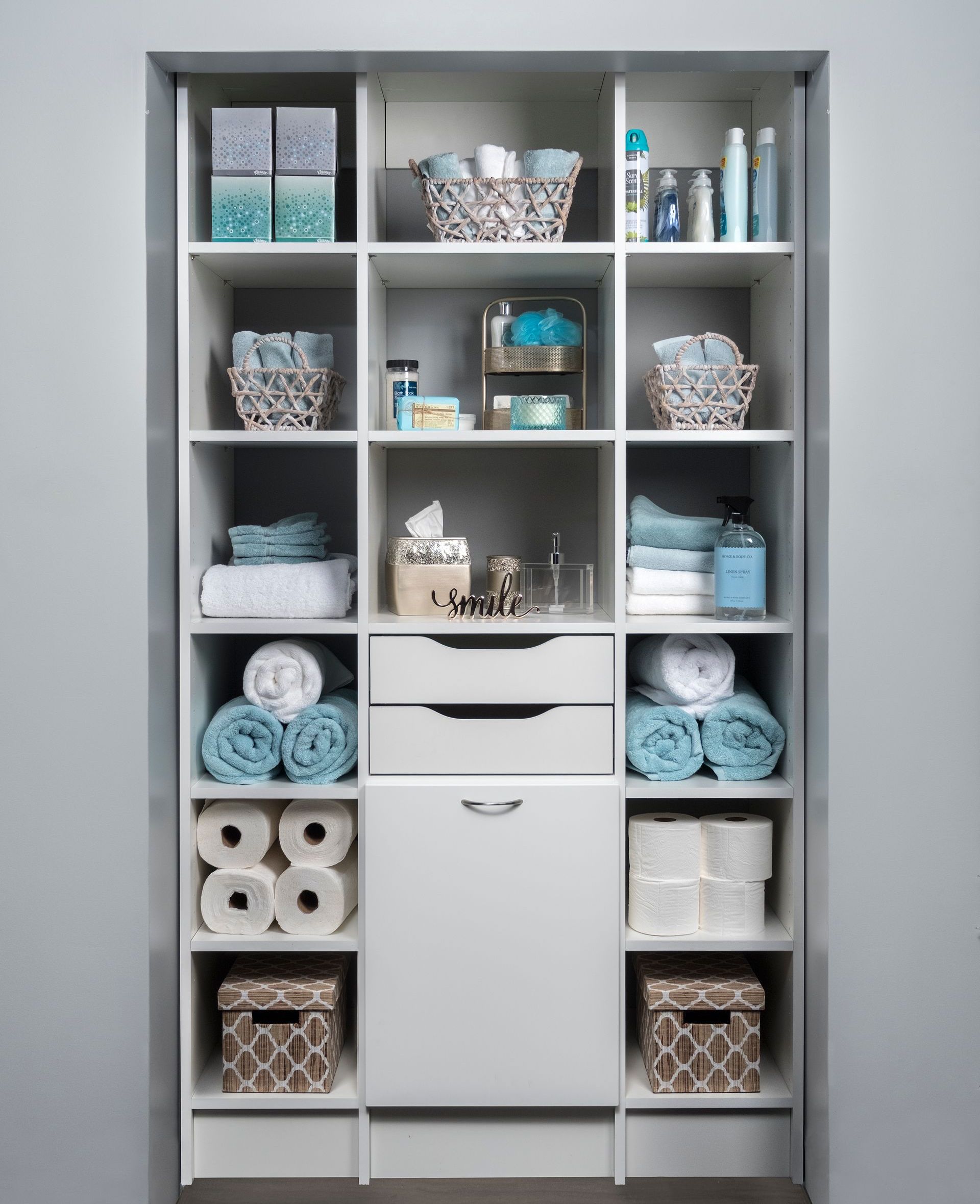 Close up of a custom closet with white open shelving against modern grey walls. 