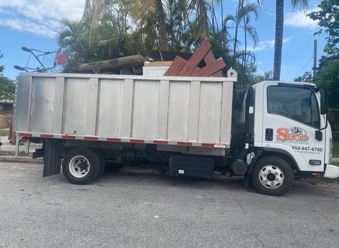 A white dump truck is parked on the side of the road.