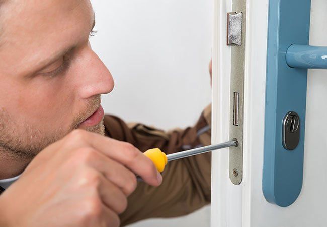 A 24 hour locksmith working on a door in Ashland, MO