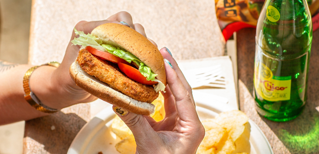 women eating a plant-based chicken burger