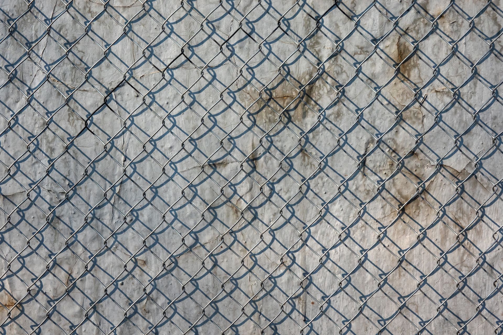 A close up of a chain link fence on a concrete surface