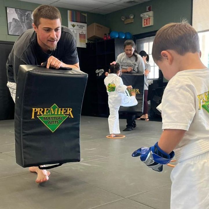 A man and a woman are practicing karate in a gym.