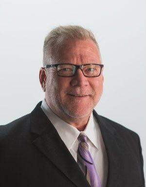 A man in a suit and tie is wearing glasses.