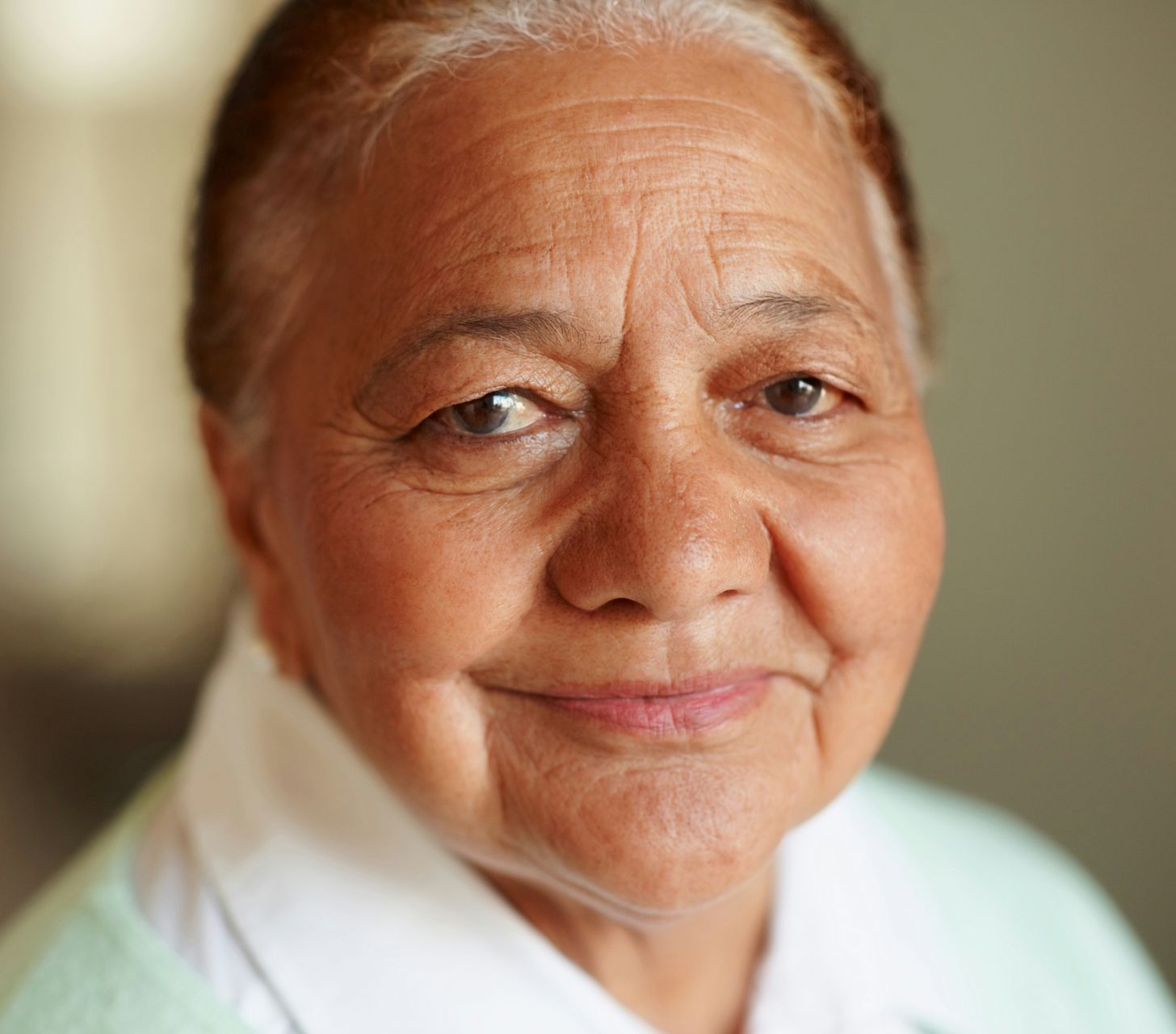 A close up of an elderly woman 's face with a smile on her face.