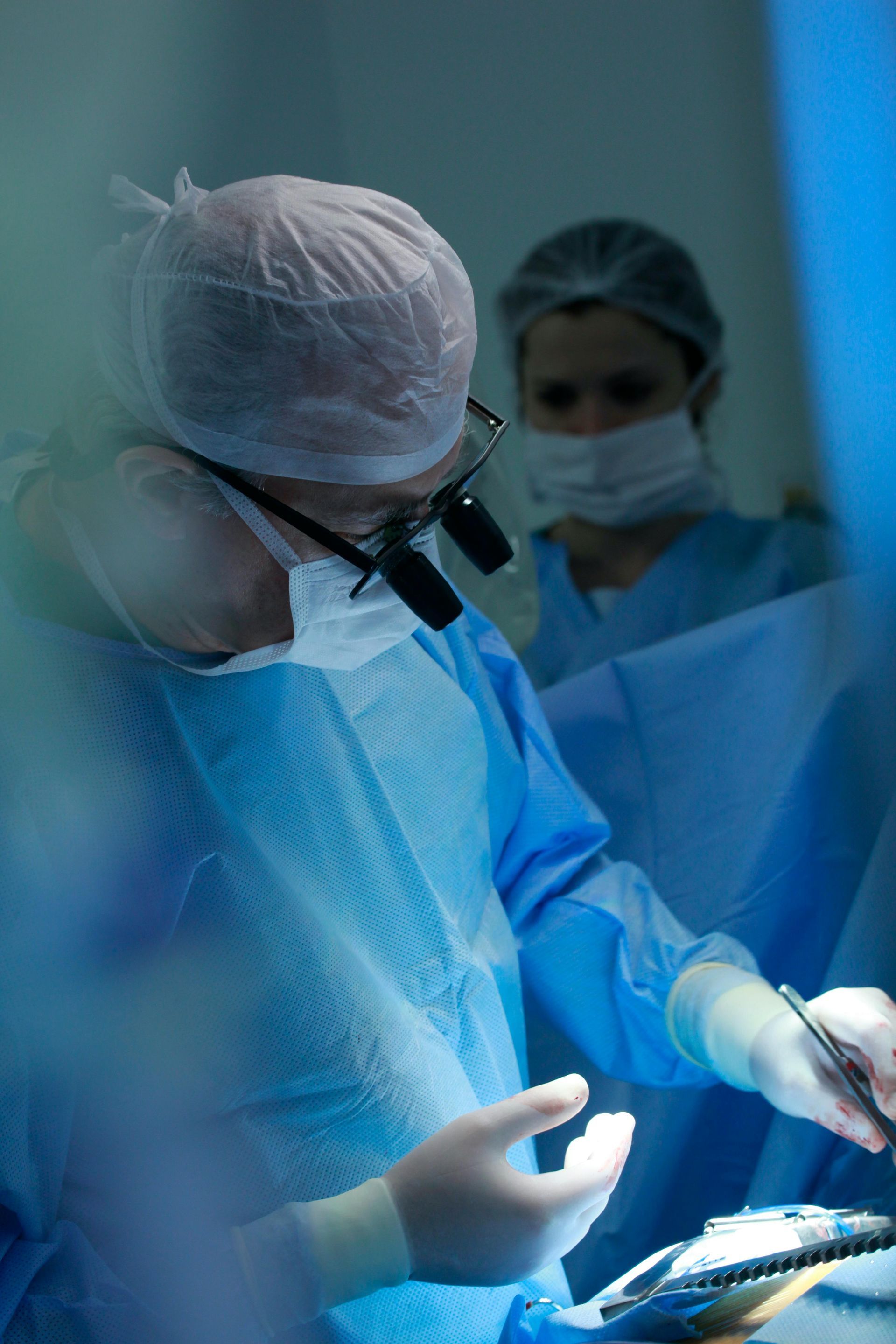 A surgeon is operating on a patient in an operating room.