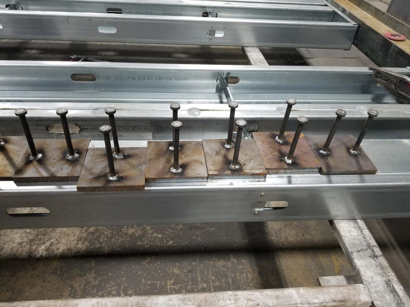 A row of metal plates with metal rods attached to them.