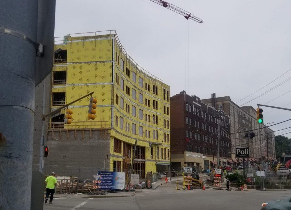 A construction site with a yellow building under construction.