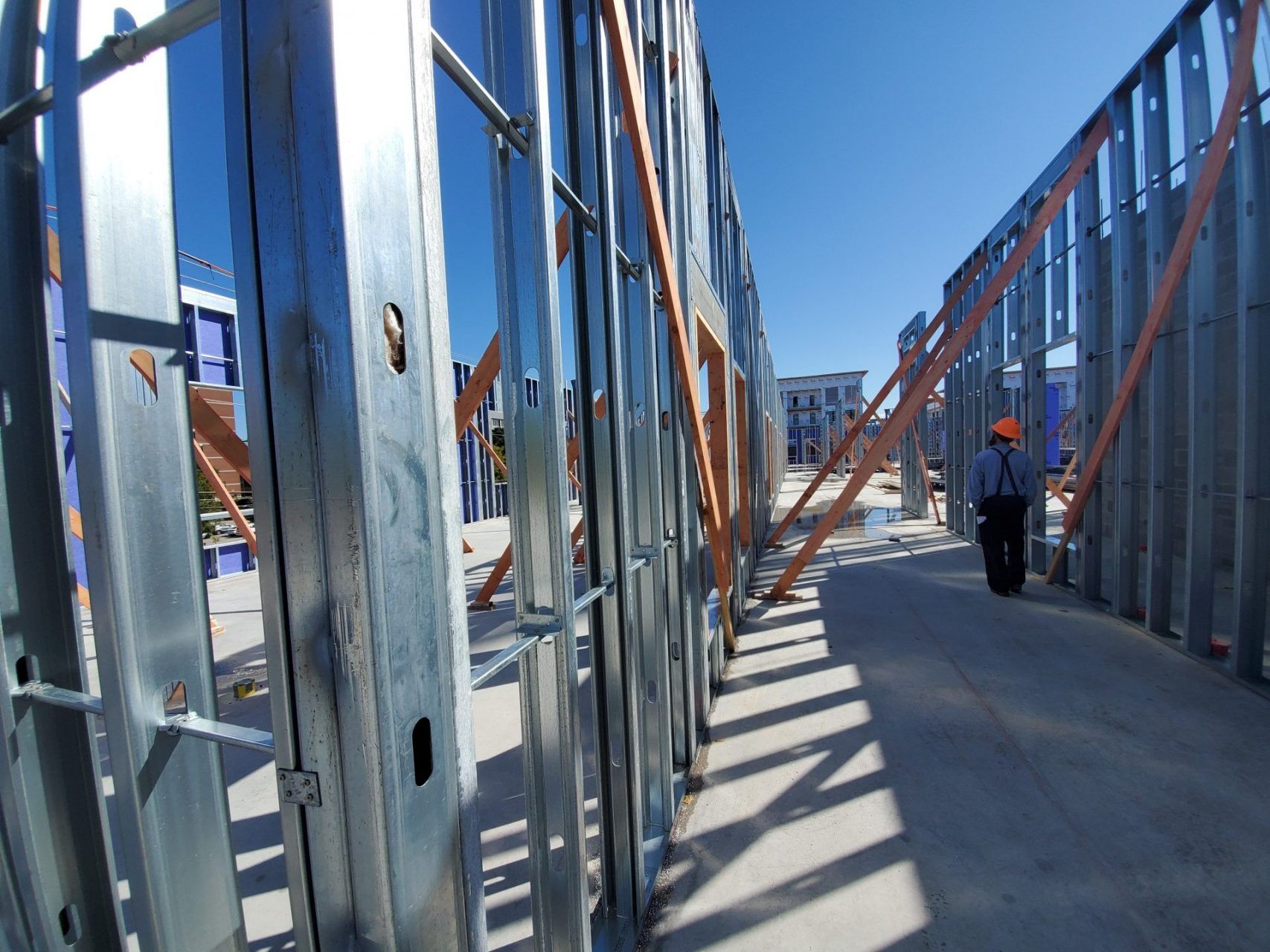 A man is walking through a building under construction.