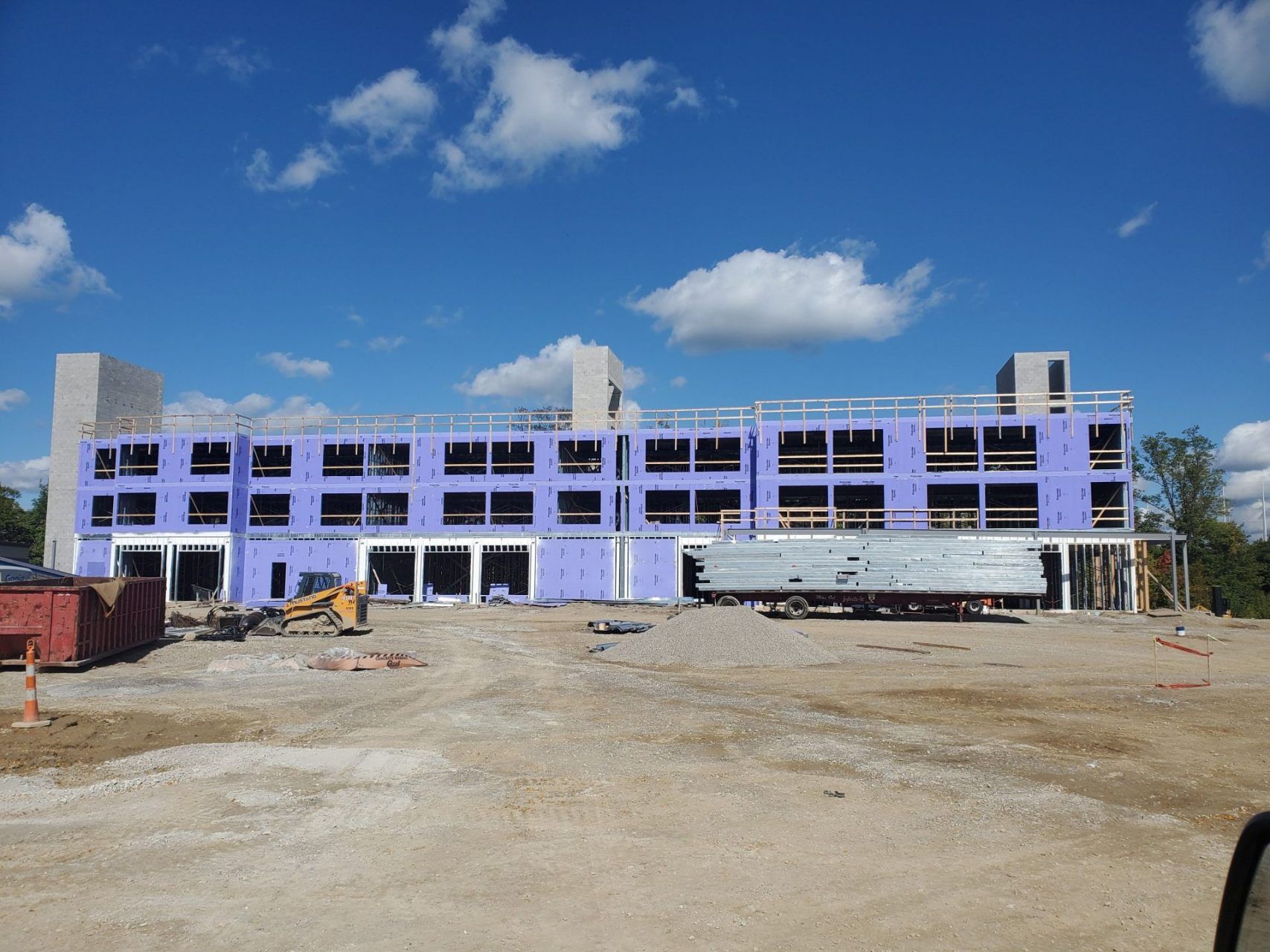 A large building under construction with a blue sky in the background.