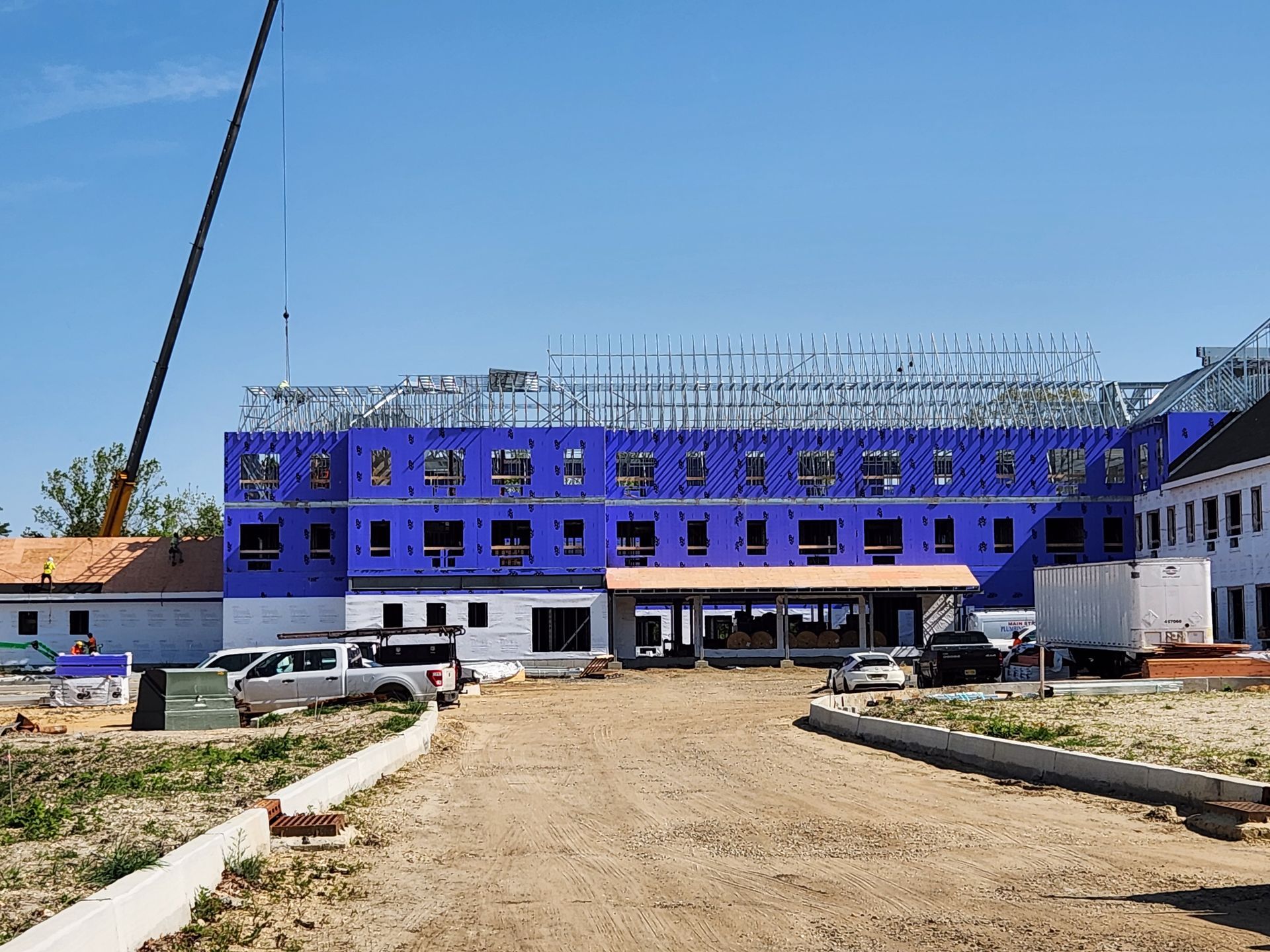 A large blue building is being built with a crane in the background.