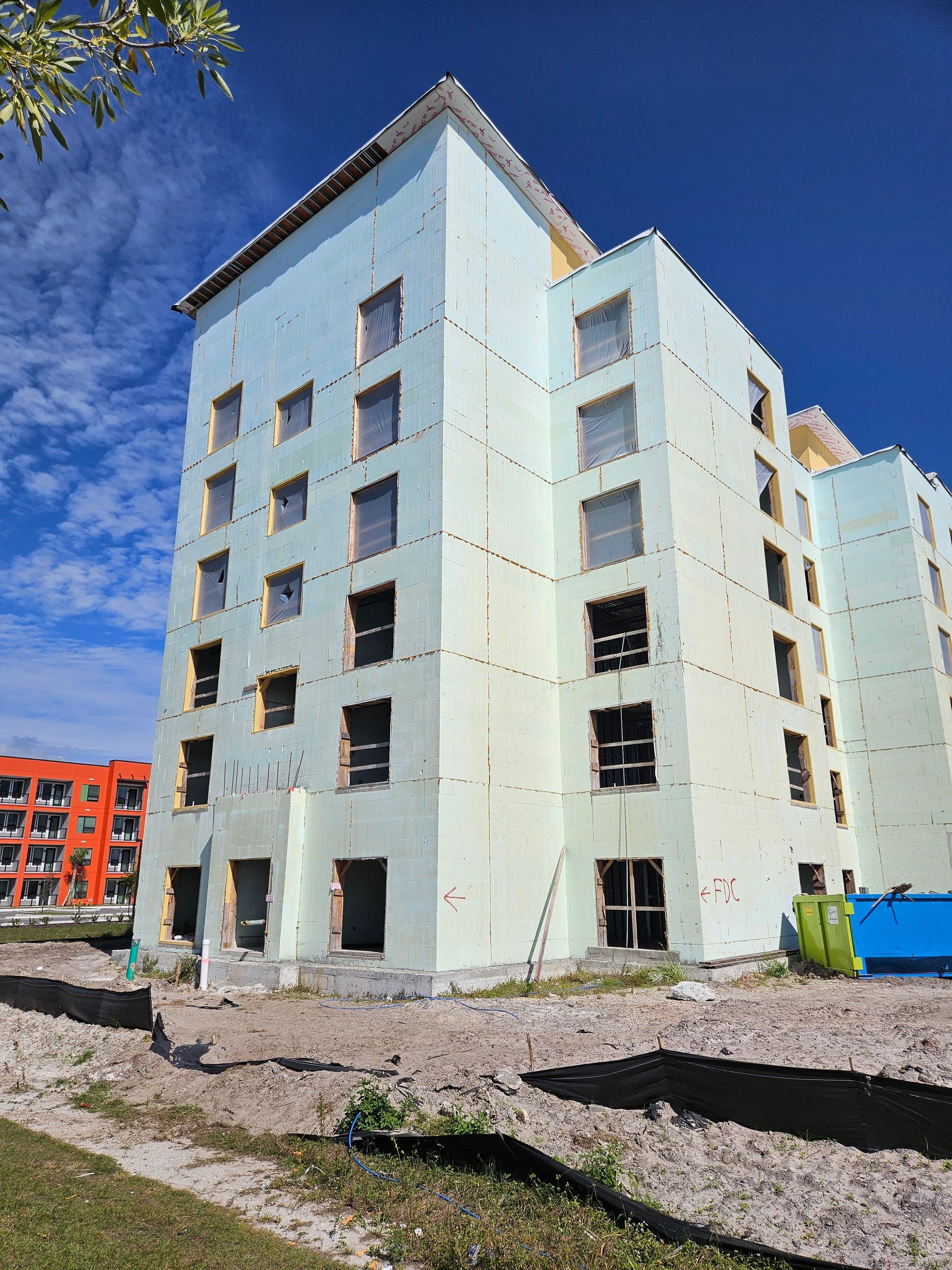 A large building with a lot of windows is under construction.