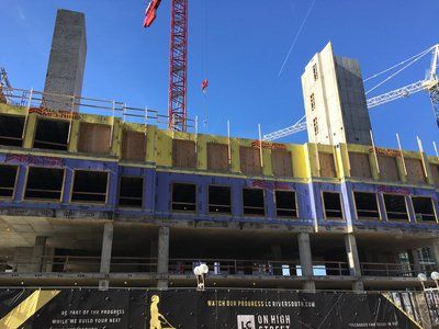 A large building under construction with a crane in the background.