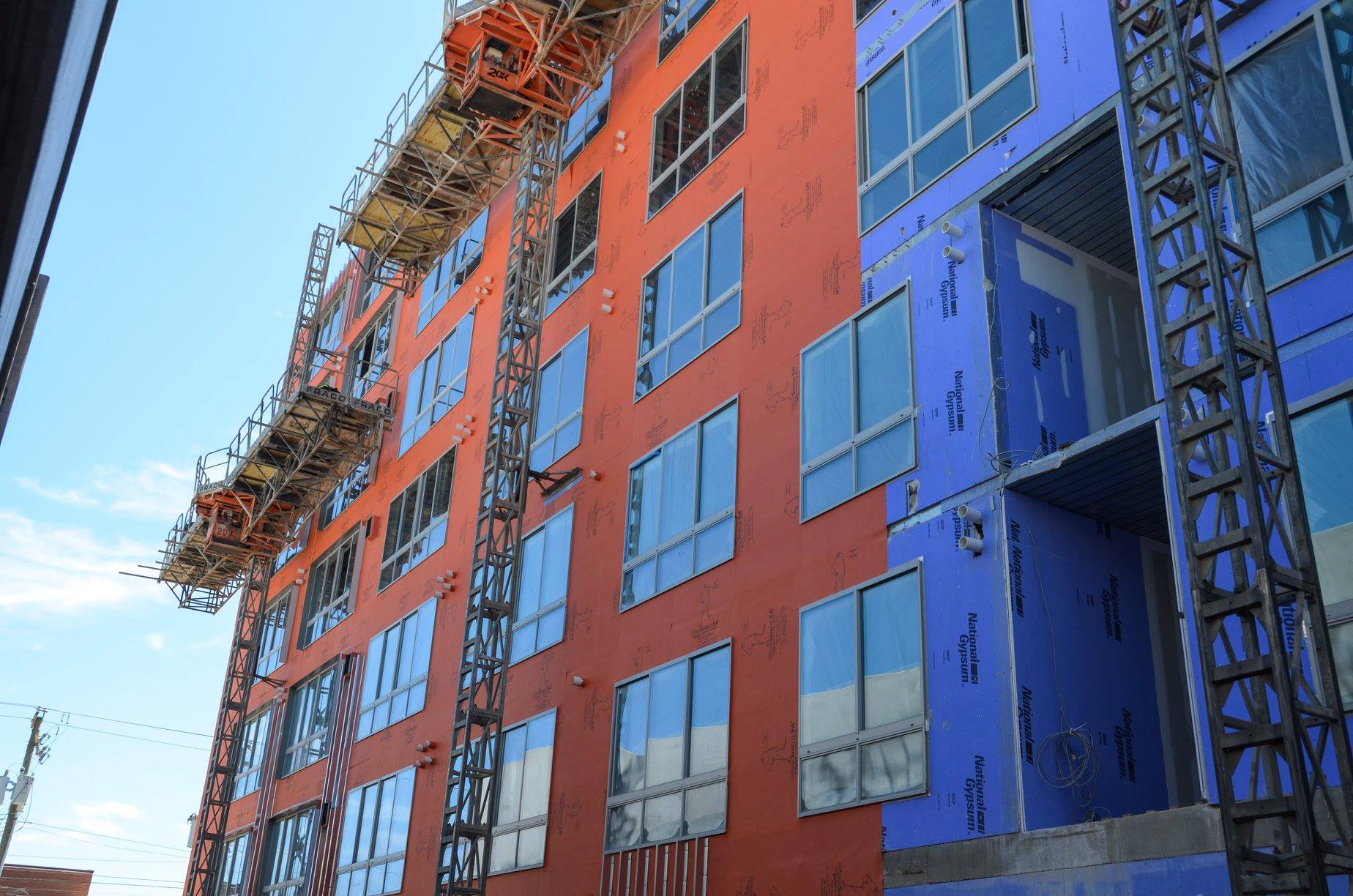 A large building with a lot of windows is under construction.