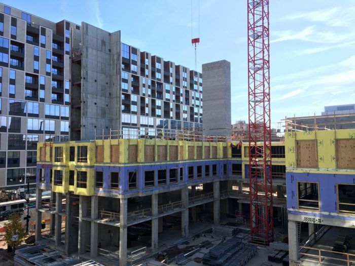 A large building under construction with a crane in the foreground.