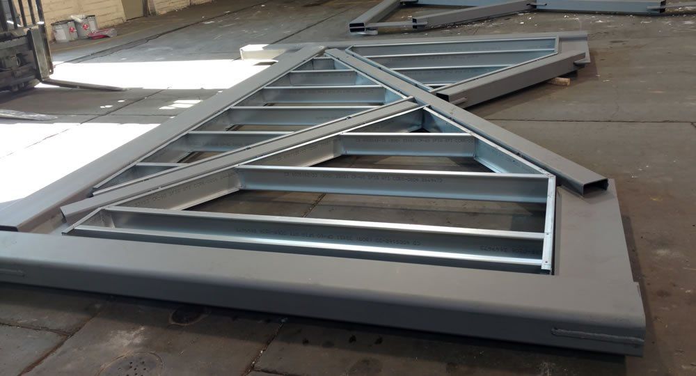 A metal structure is sitting on the ground in a warehouse.