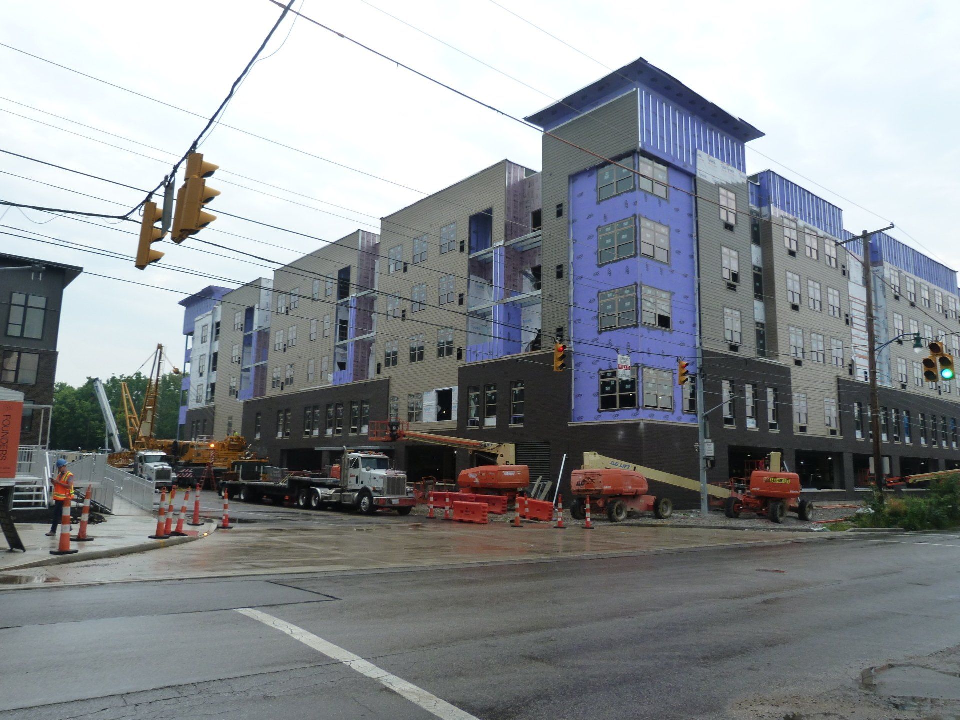 A large building is being built on the corner of a street.