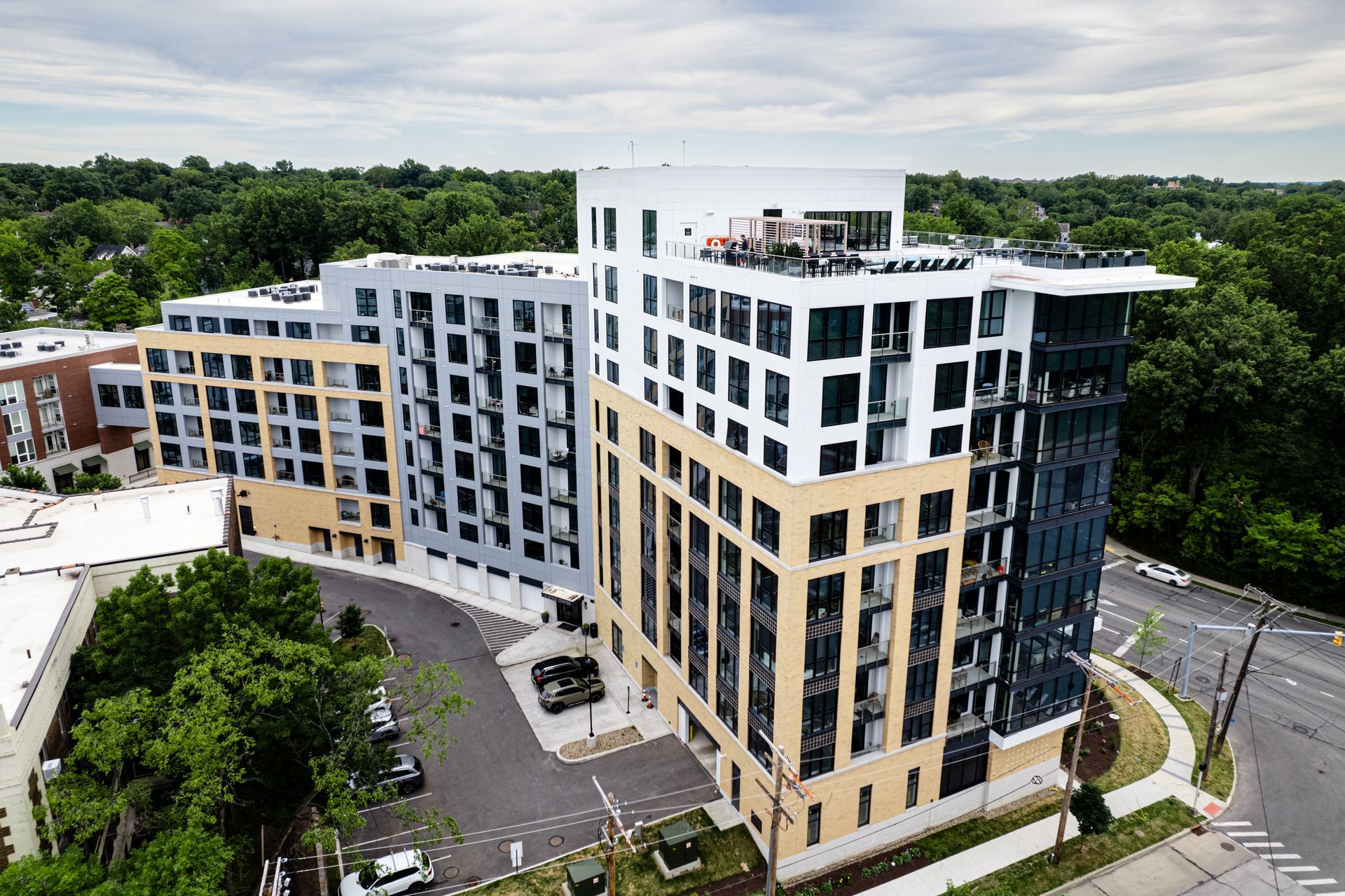 An aerial view of a large building with a lot of windows surrounded by trees.
