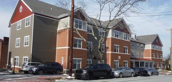 A large brick building with vehicles parked in front of it.