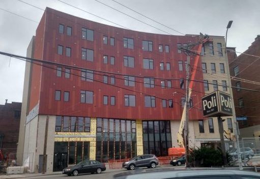 A large building with a lot of windows is under construction.