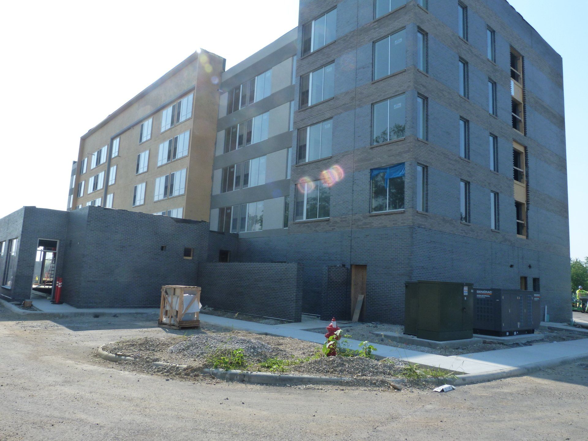 A large building under construction with a fire hydrant in front of it.
