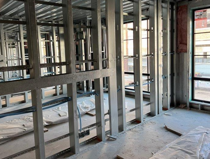 A room under construction with a lot of metal frames and windows.
