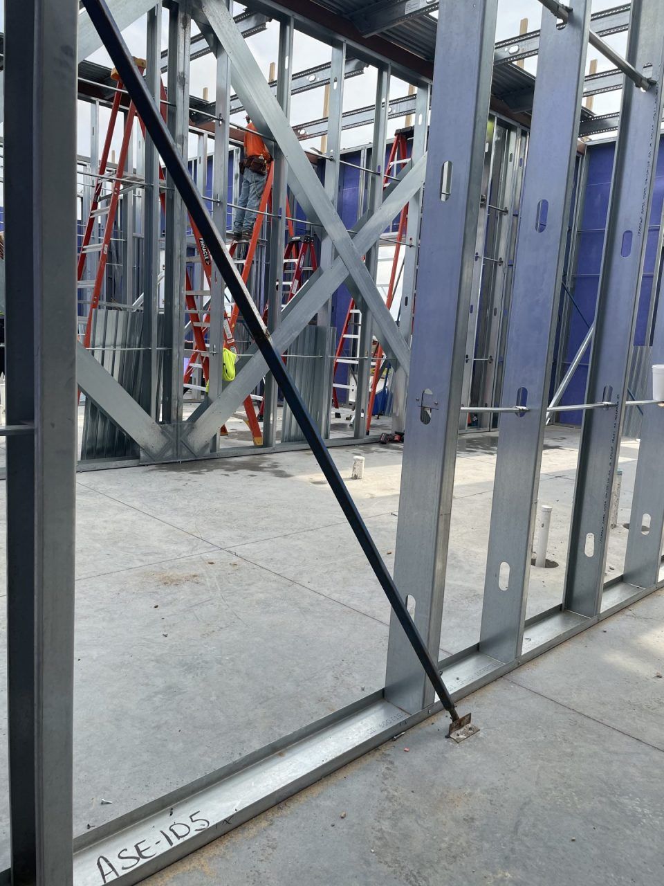 A large metal structure is being built on a construction site.