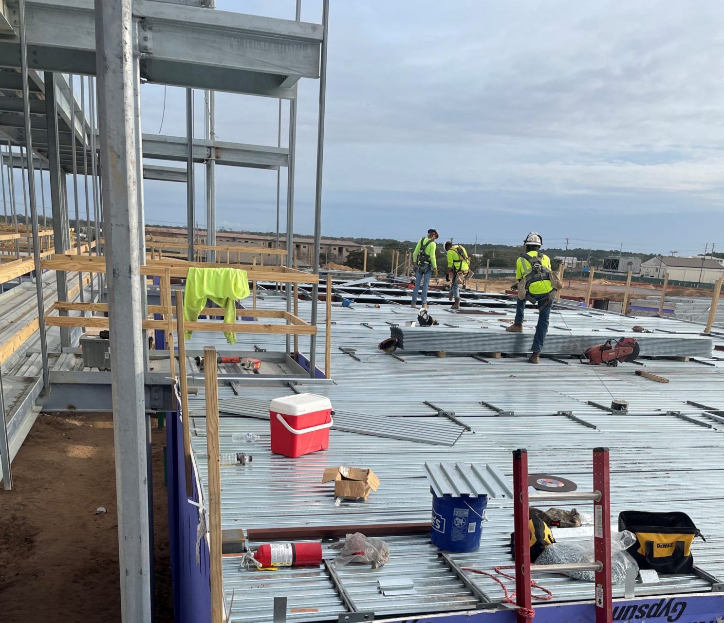 A group of construction workers are working on the roof of a building under construction.
