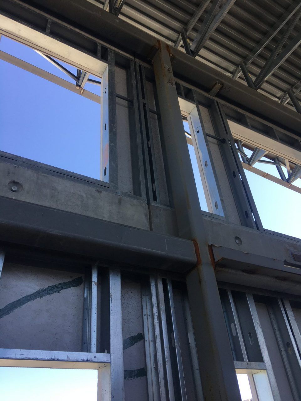 A close up of a building under construction with a blue sky in the background.