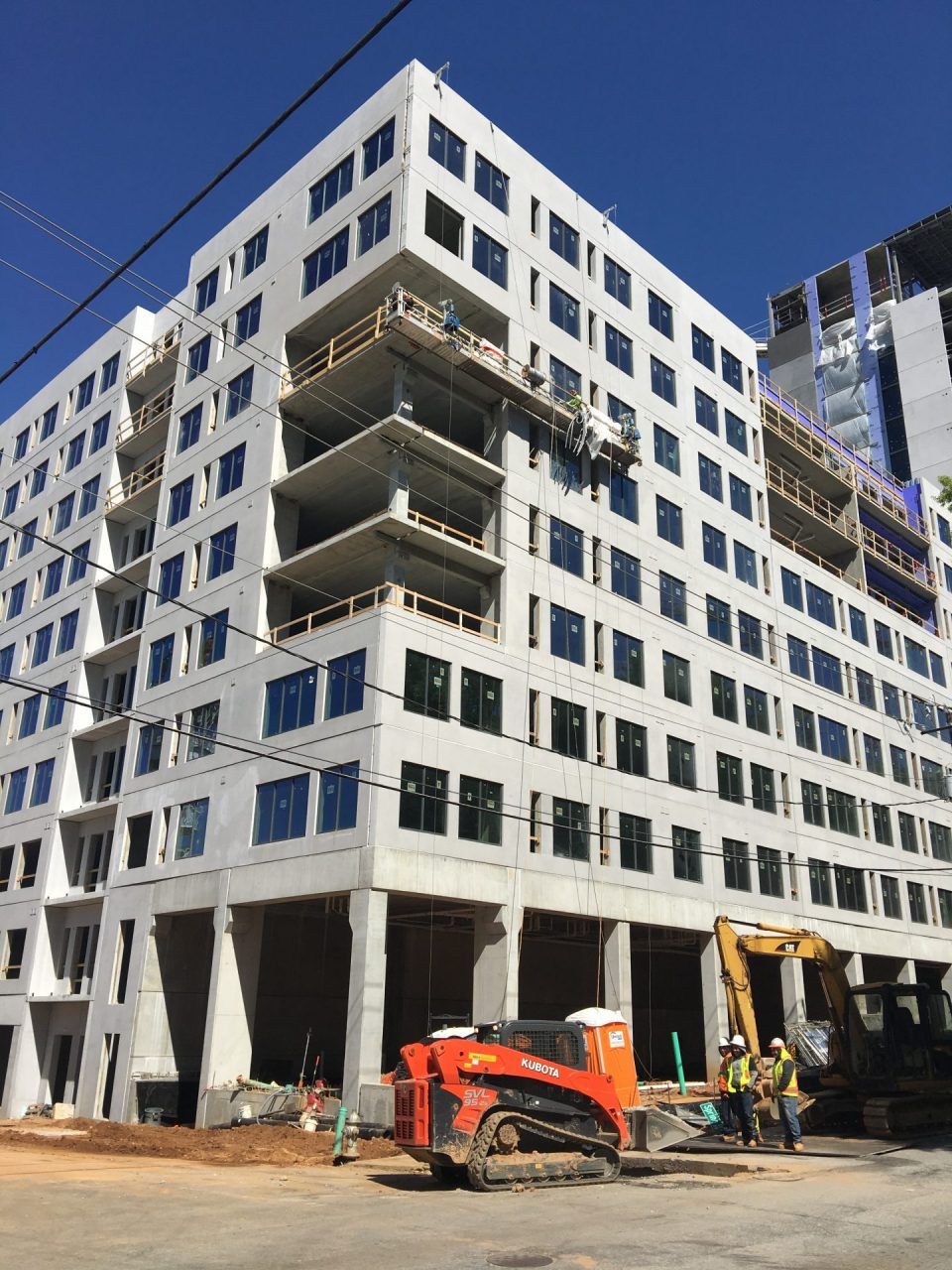 A large building under construction with a bulldozer parked in front of it.