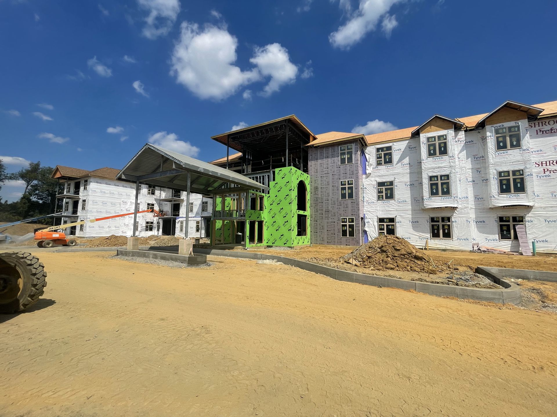A large apartment building is being built on a sunny day.