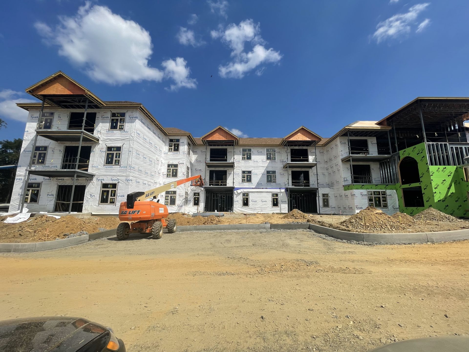 A large building under construction with a lot of dirt in front of it.