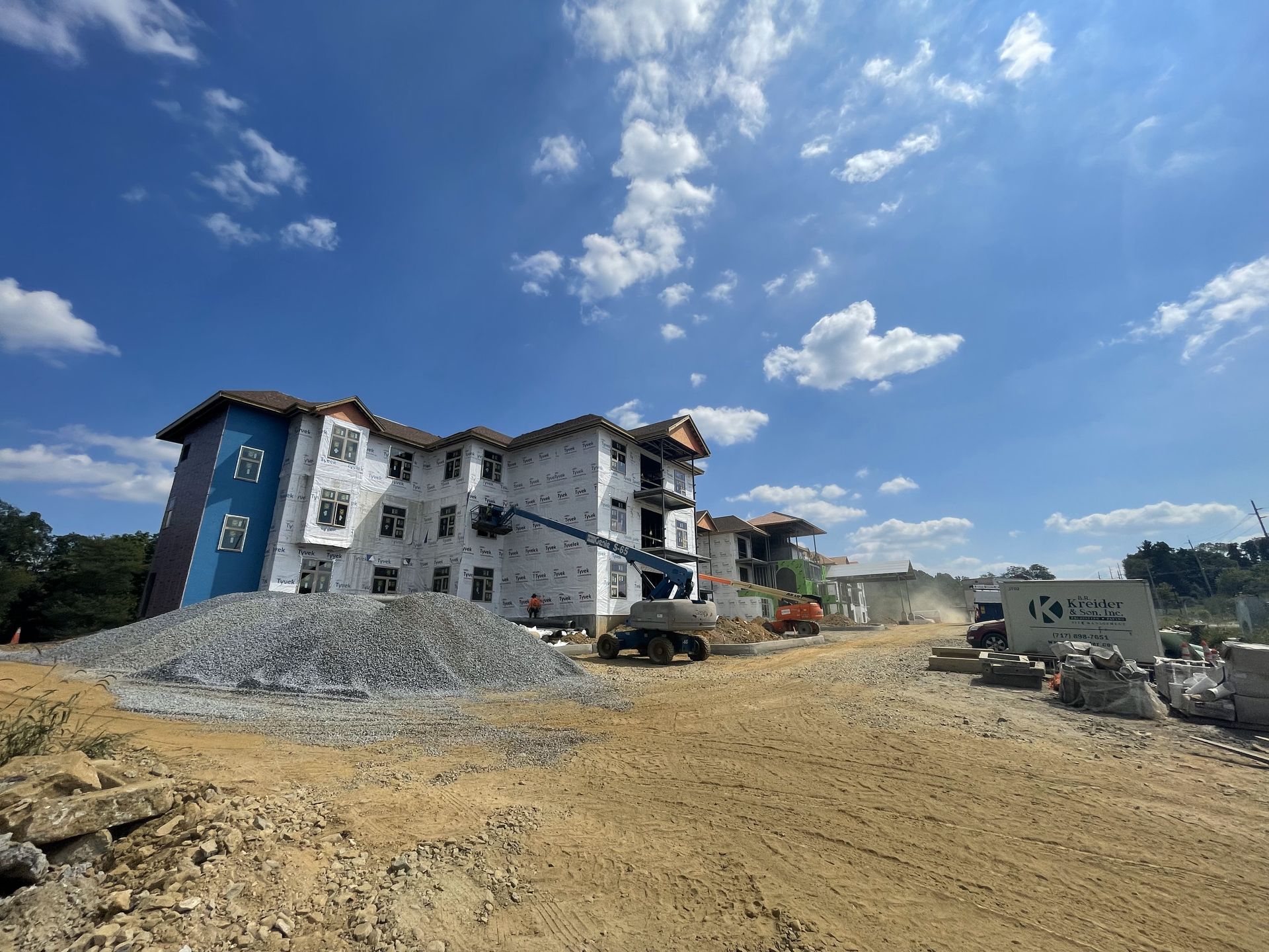 A large building is being built in the middle of a dirt field.