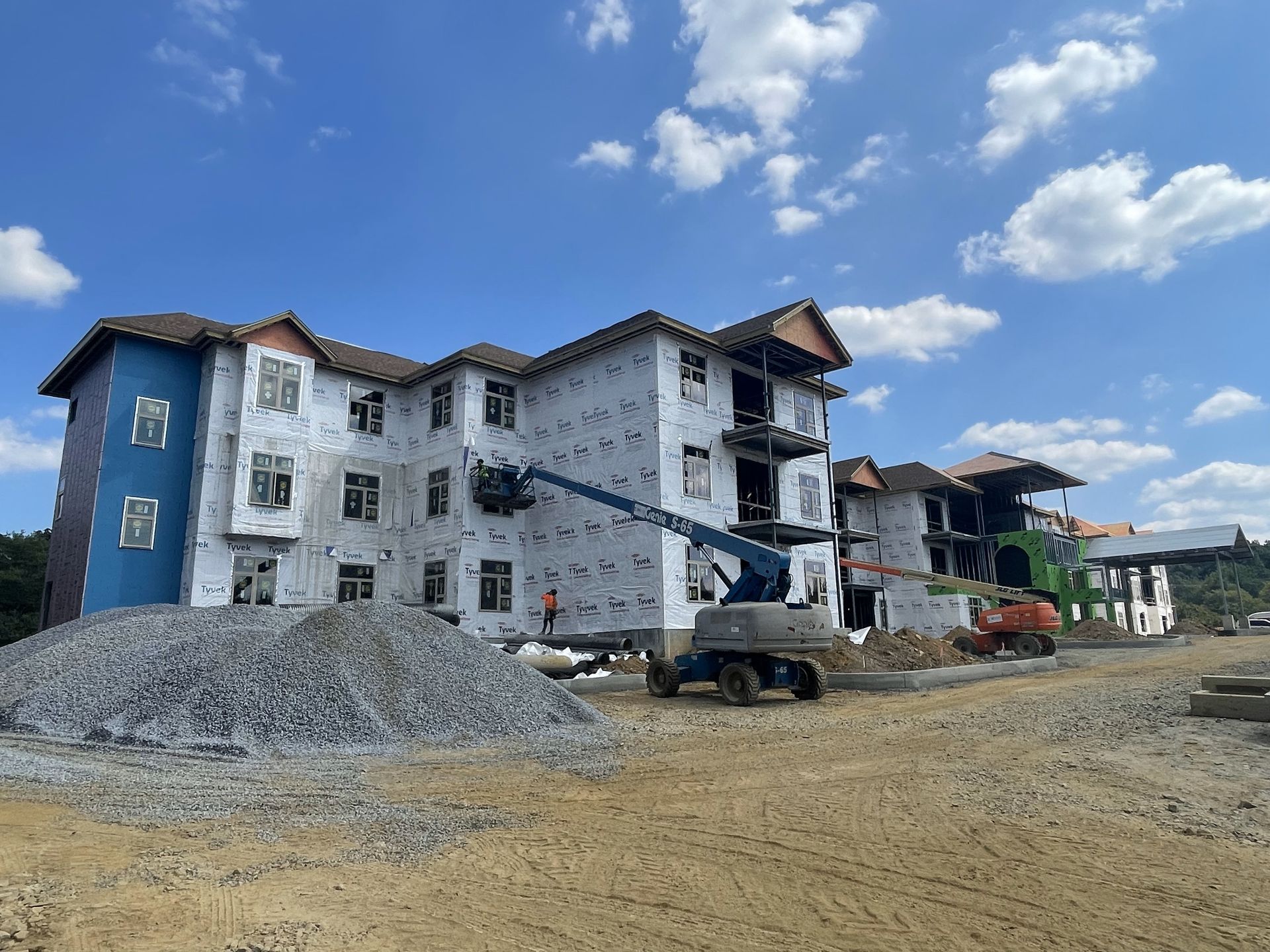 A large building is being built on a dirt field.