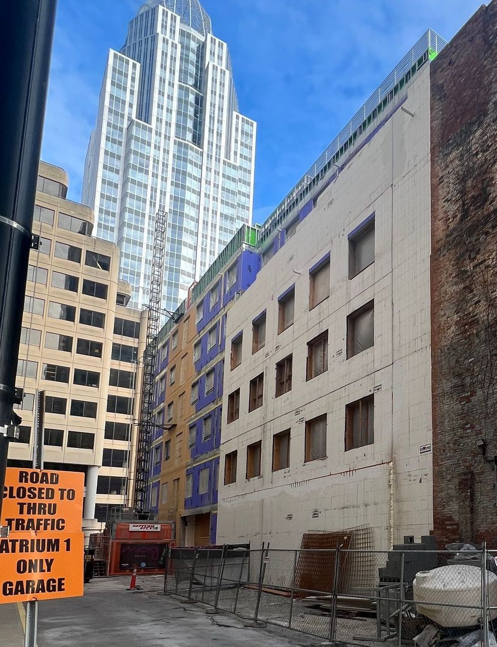 A large building under construction with a sign that says