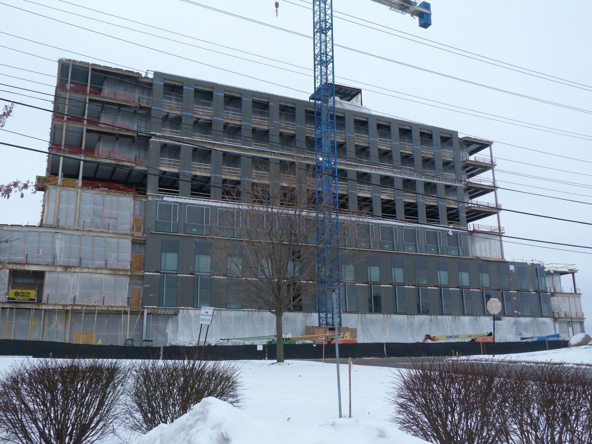 A large building under construction with a crane in front of it.