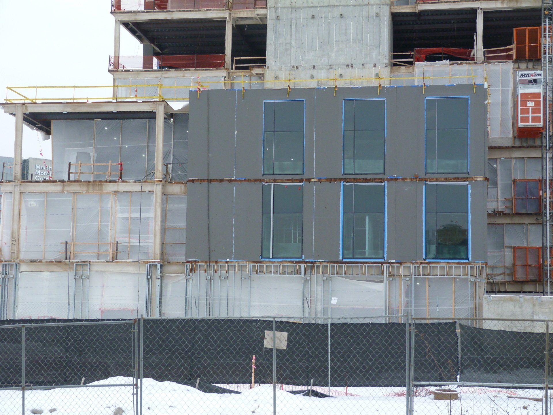 A large building under construction with a fence around it.