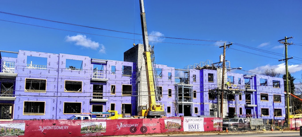 A large building under construction with a crane in front of it.