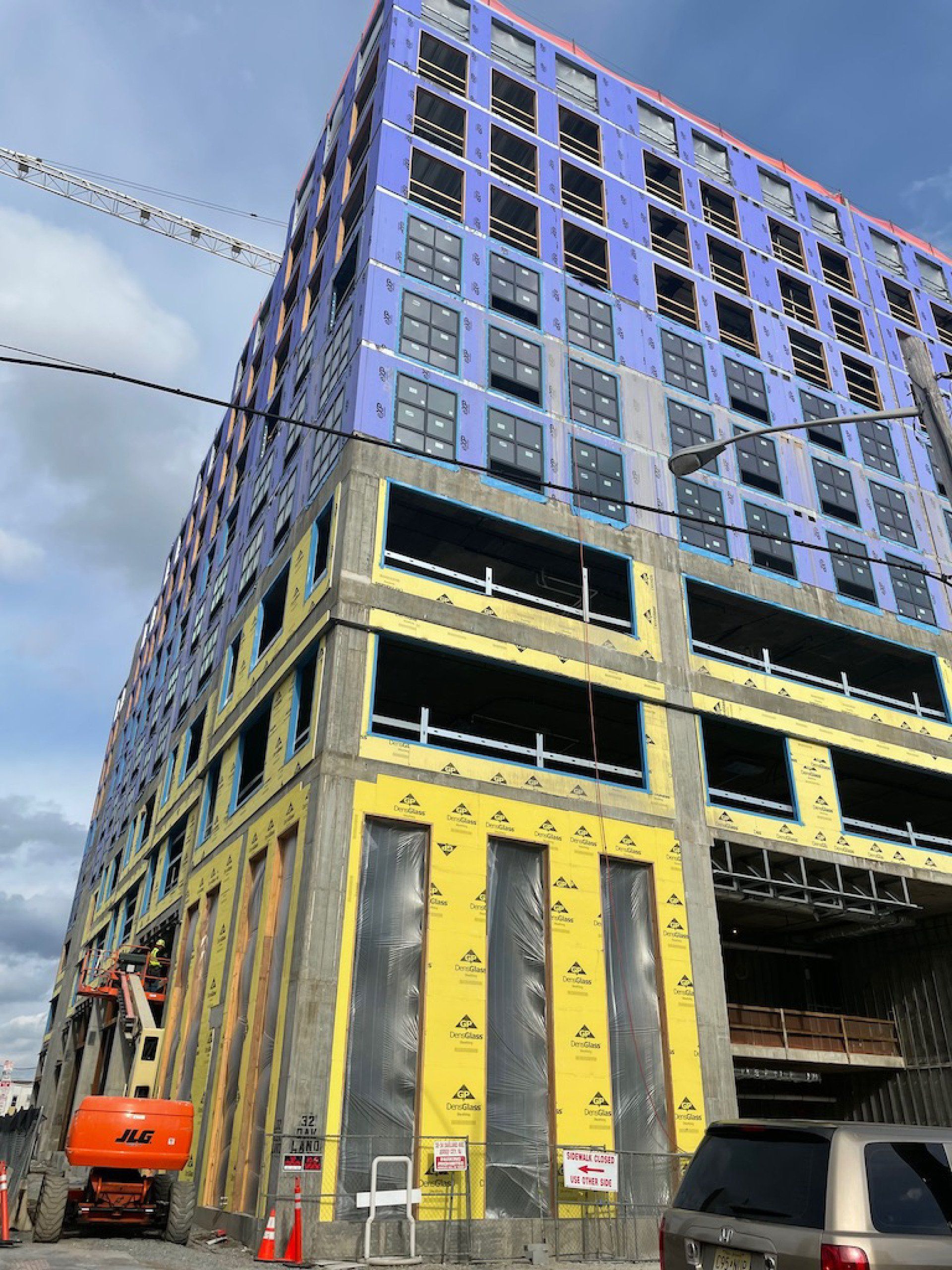 A large building under construction with a crane in the background.