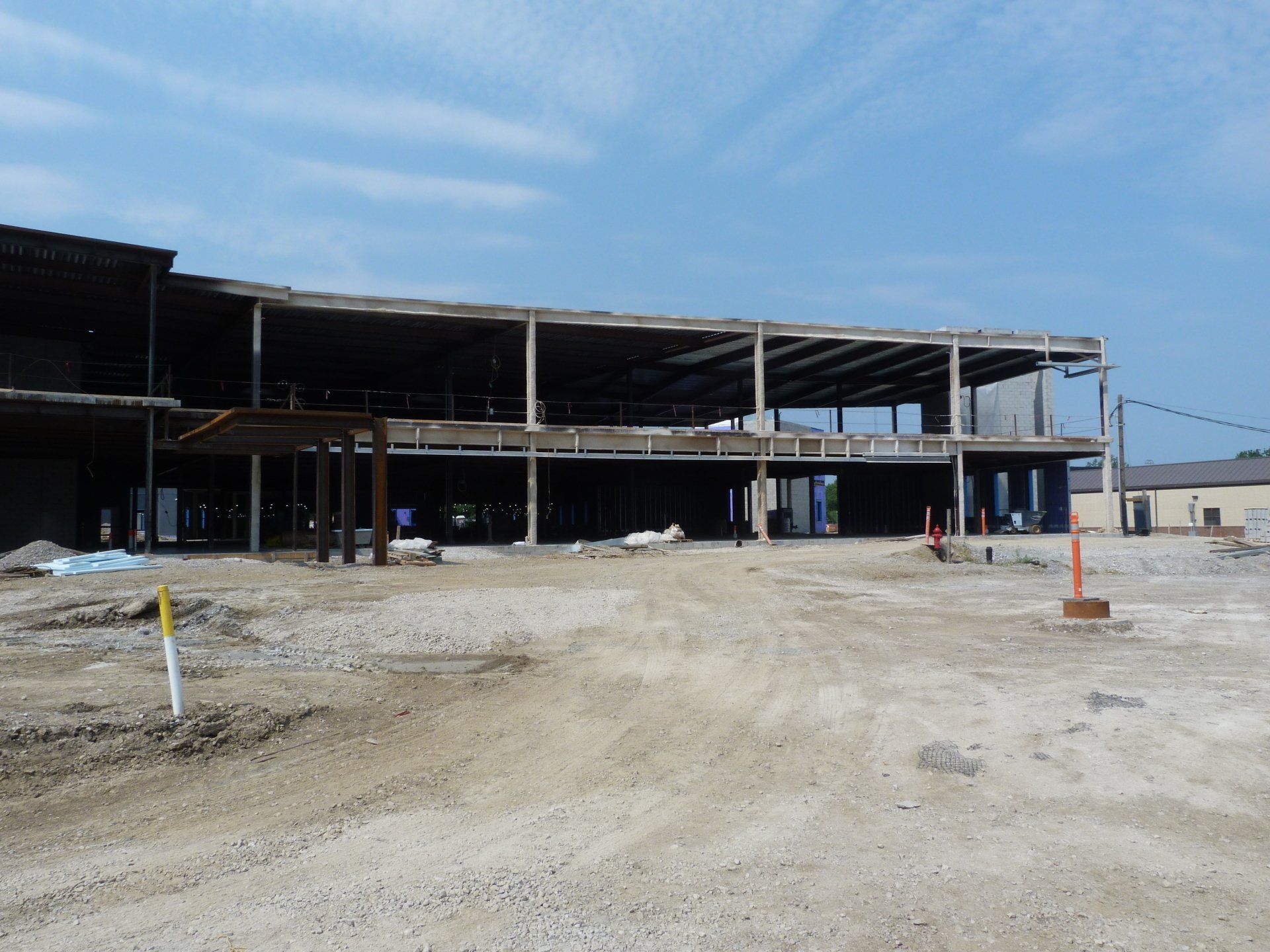 A large building is being built on cleared dirt. 