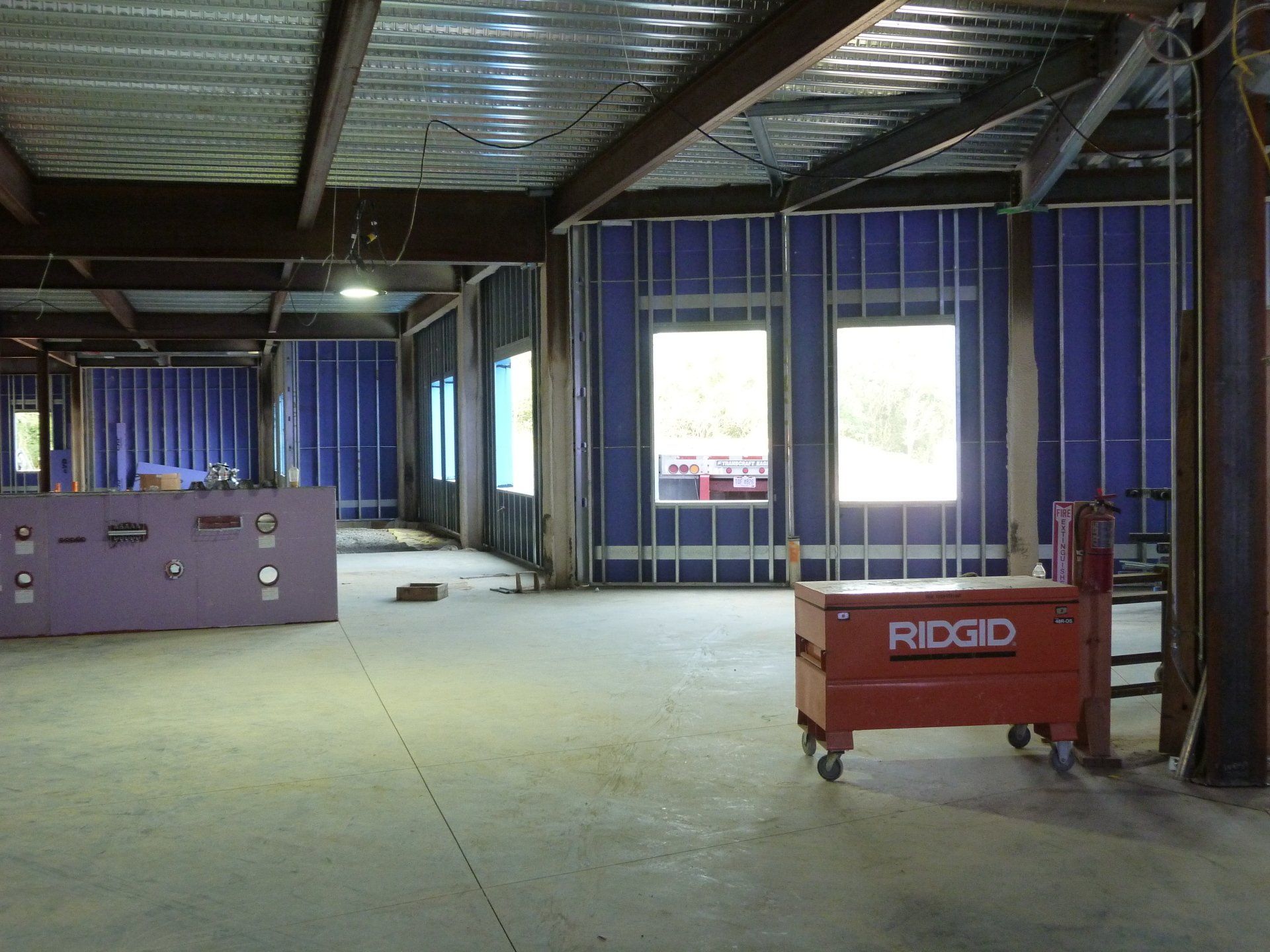 A red ridgid toolbox sits in an empty room.