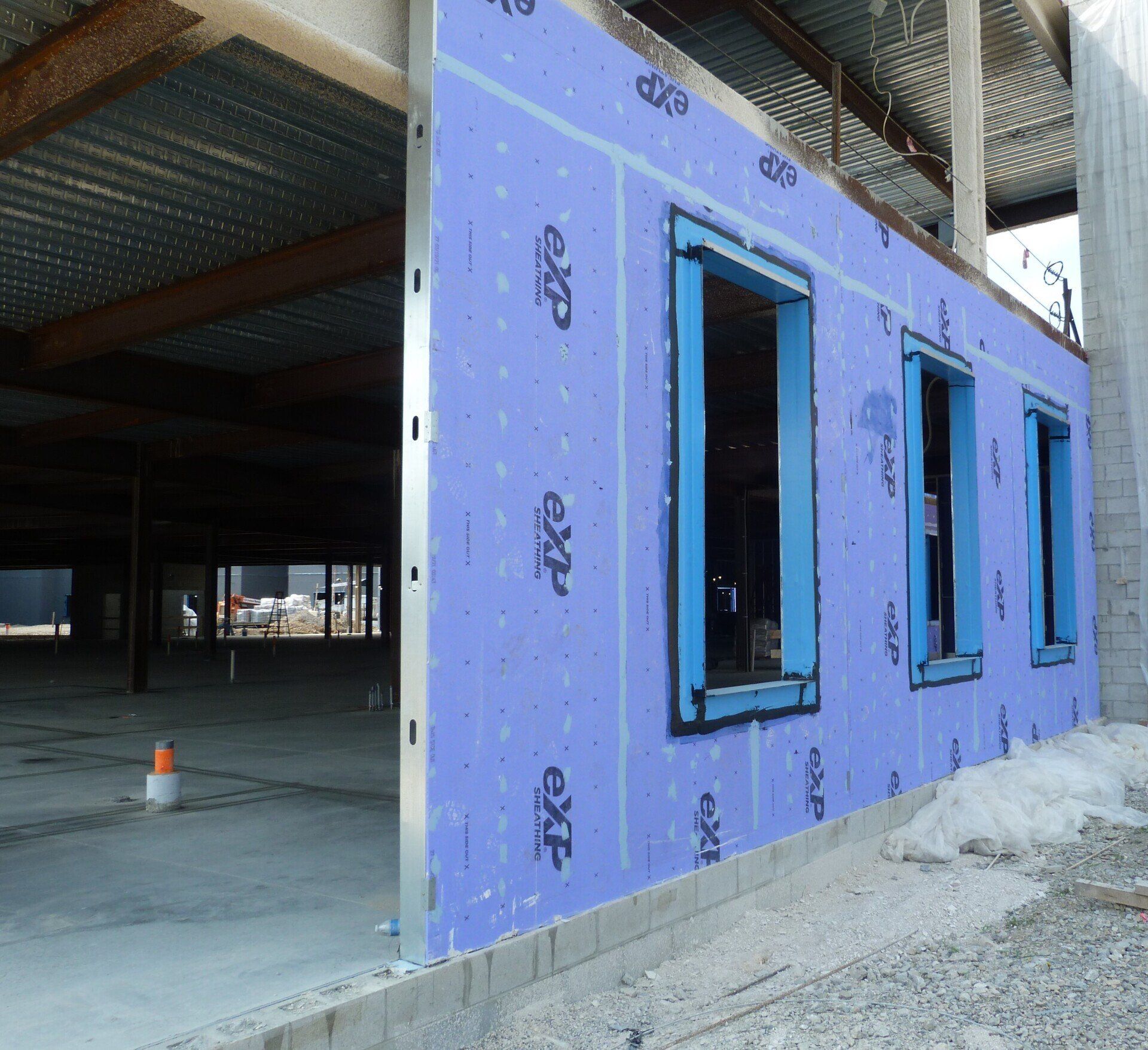 A building under construction with a purple wall.