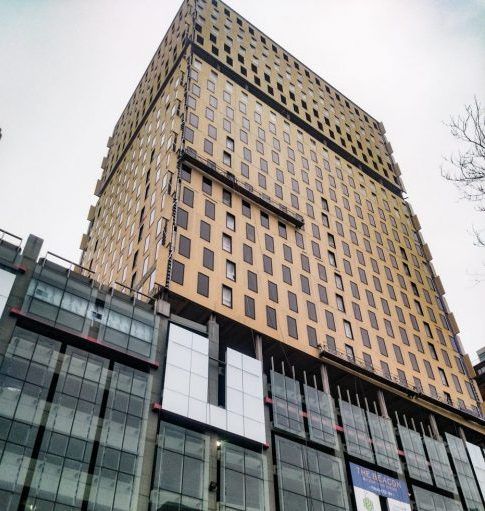 Looking up at a tall building with lots of windows.