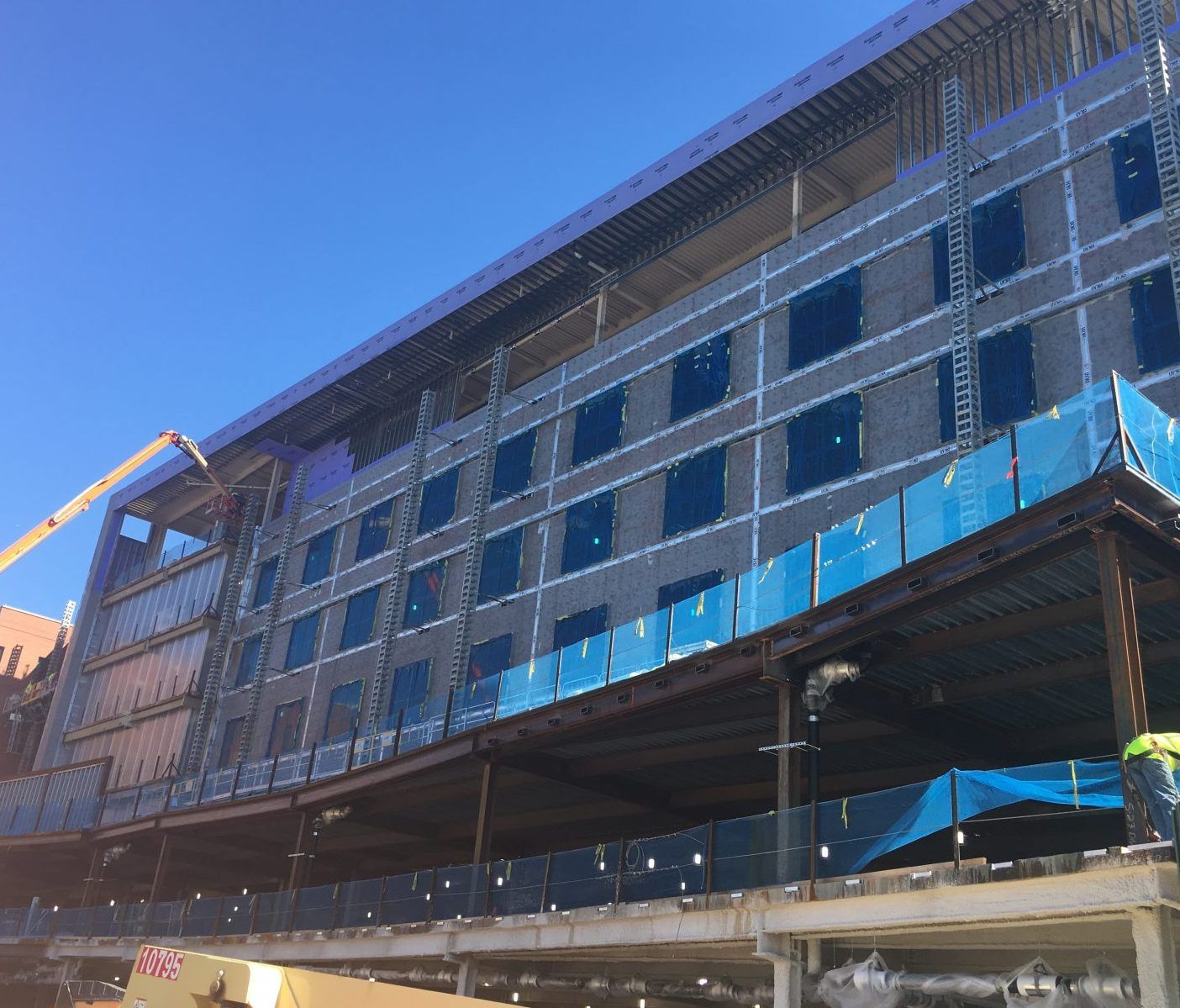 A large building under construction with a crane in front of it.